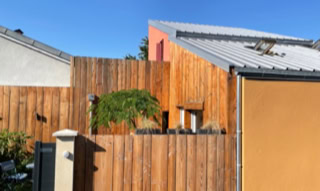 Tiny house urbaine à Vaulx-en-velin, vu de l'extérieur sur sa façade et sa cloture bois.