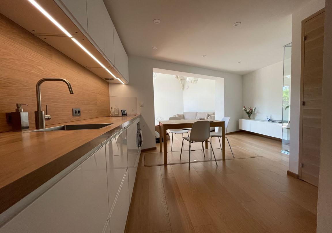 Cuisine neuve et lumineuse avec un plan de travail en bois.