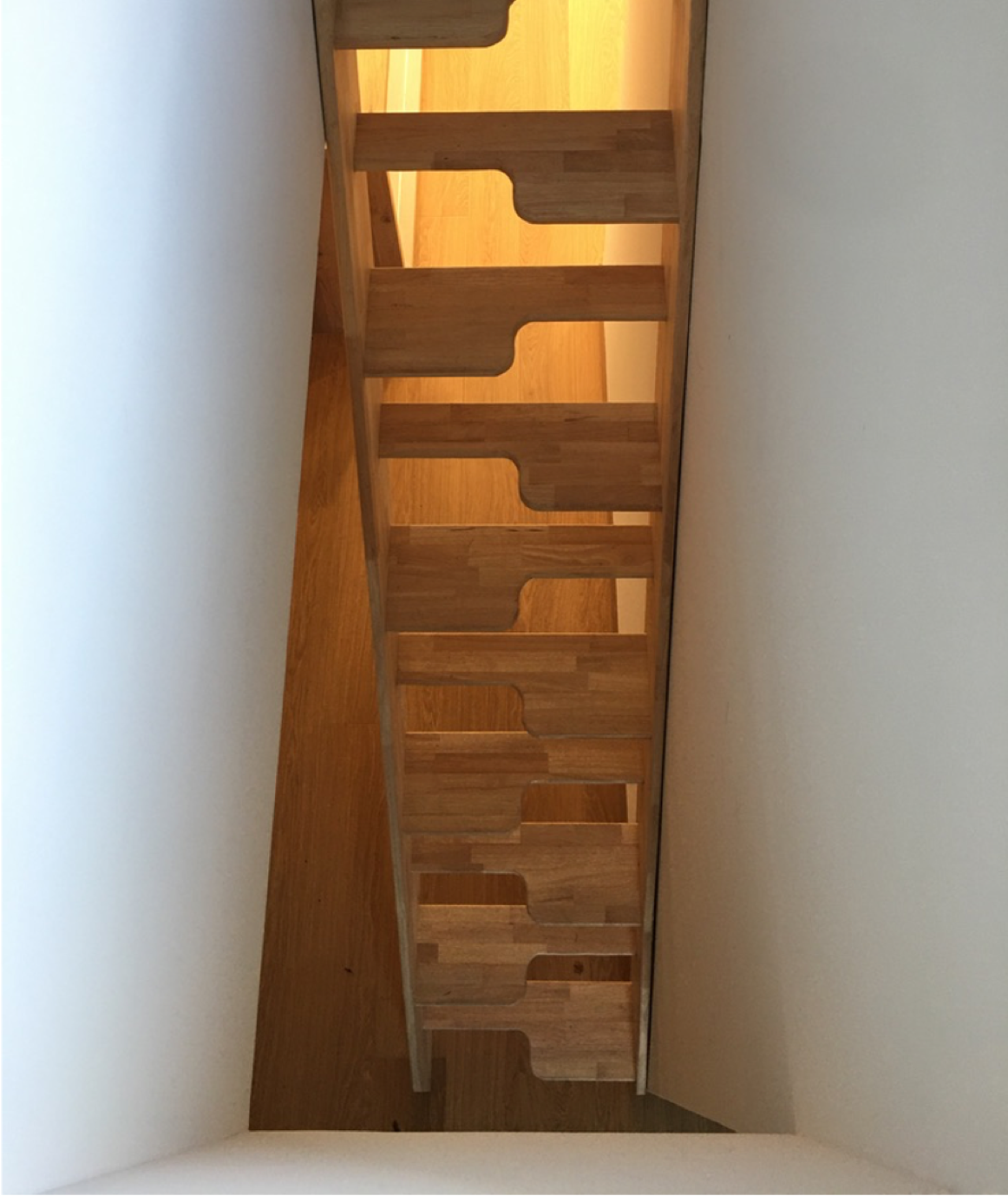 Escalier à pas décalé en bois dans un espace étroit.